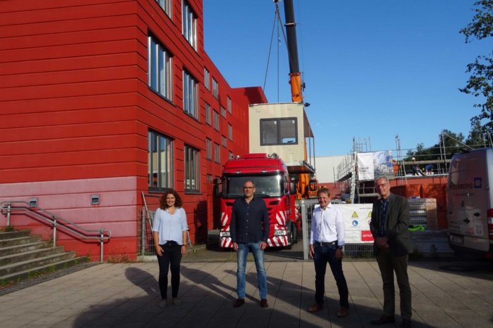 Schwerins IB-Chefin Stefanie Trost, Schulleiter Thomas Schott , OB Rico Badenschier und ZGM-Werkleiter Ulrich Bartsch bei der Montage des ersten Moduls für die Horterweiterung der Astrid-Lindgren-Schule.  © Landeshauptstadt Schwerin/Michaela Christen